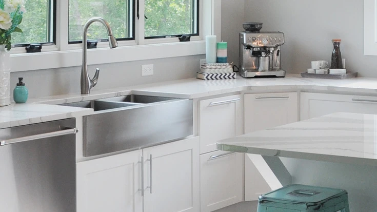 white kitchen with stainless steel sink, Brittanicca quartz countertops and blue kitchen island stools