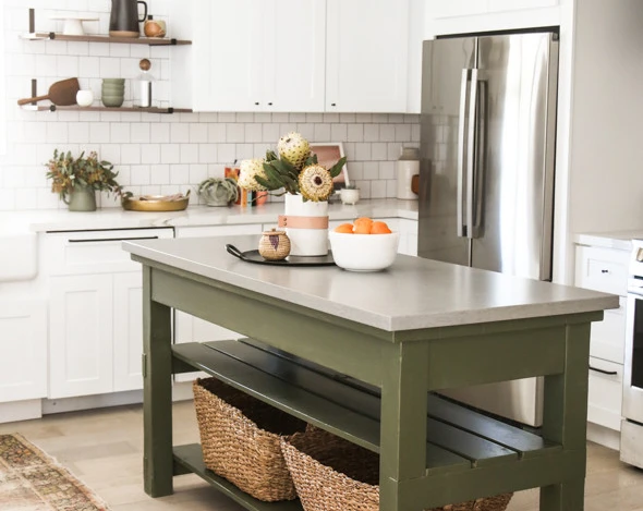 a modern farmhouse kitchen with an open green quartz kitchen island topped with Cambria Carrick gray countertops and a tray with fruit and flowers on top. 