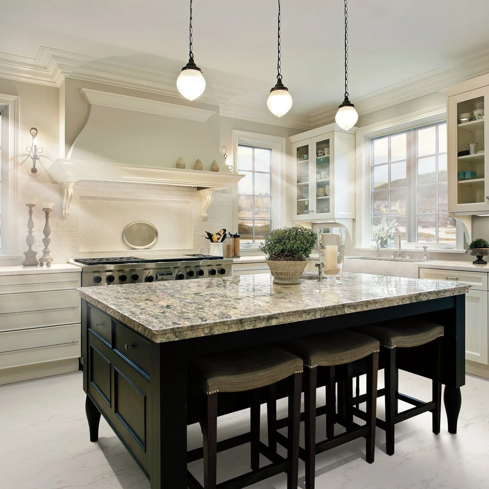 a traditional kitchen with an open island painted black and topped with Cambria Wentwood countertops, a large range and eye-catching hood, and white cabinets with glass doors.