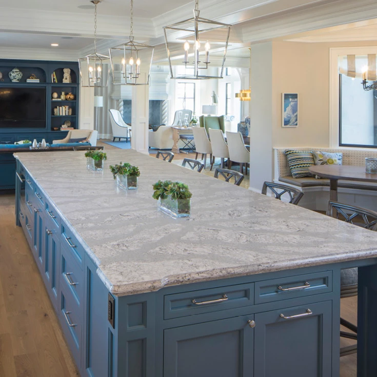 a spacious kitchen island with Cornflower blue cabinets and topped with Cambria Summerhill quartz countertops to create a coastal look.
