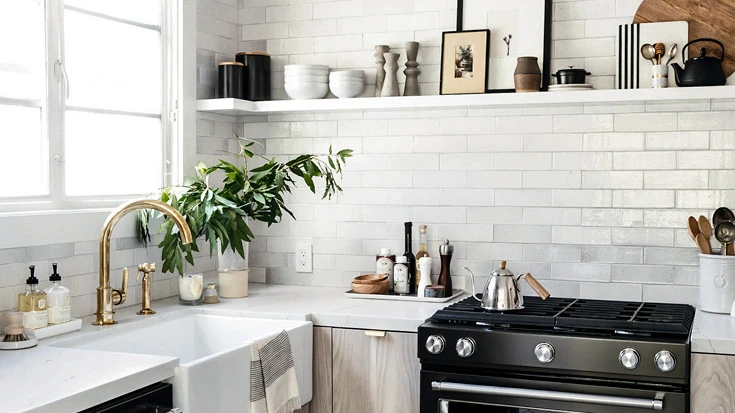a small kitchen with oak cabinets, a gray tile backsplash, and Ella Matte white quartz countertops