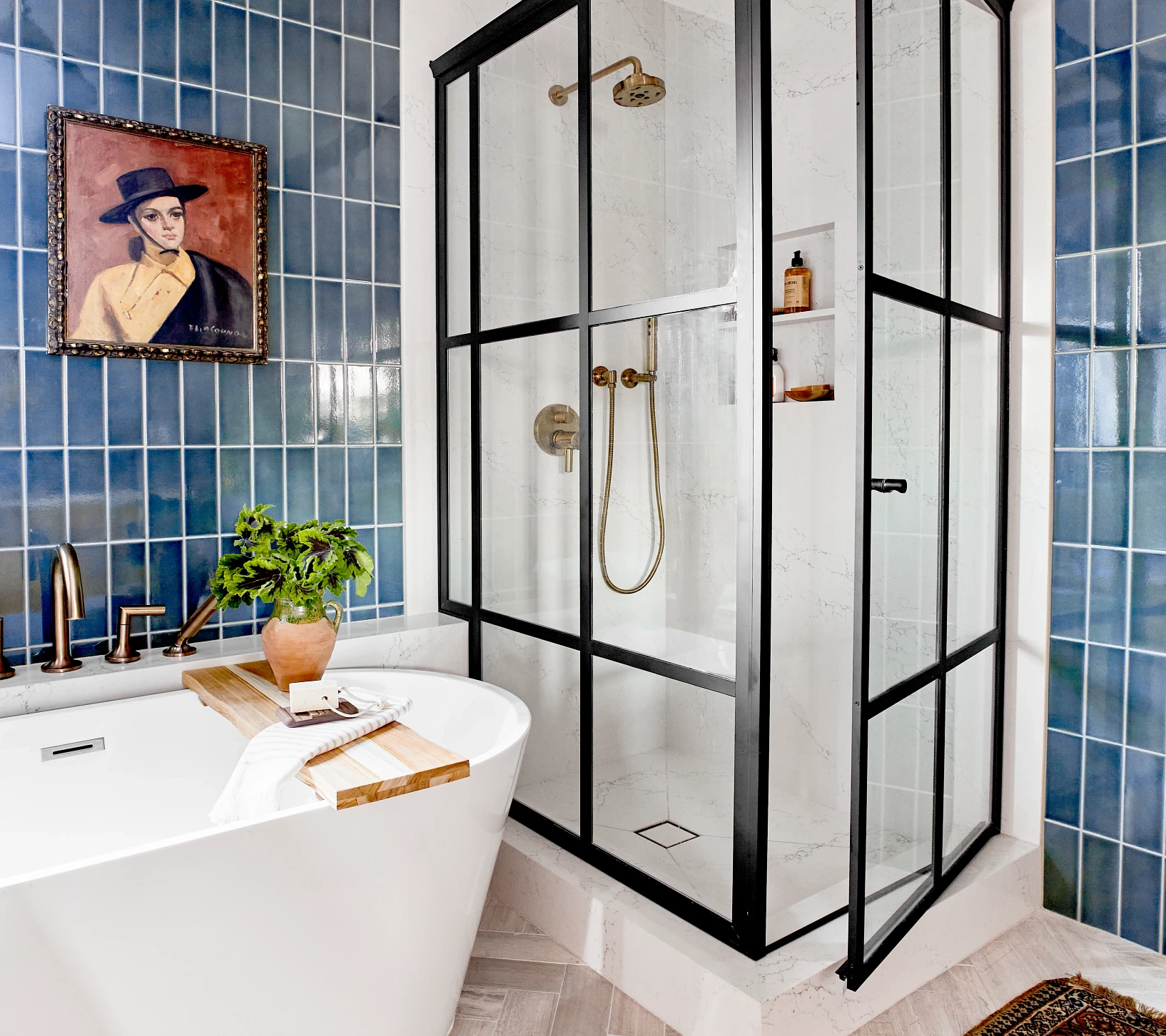a primary bathroom with Cambria Colton countertops and matching Colton shower surround and with black shower wall windos and door, grand white bathtub, and gorgeous blue tiles on the walls.