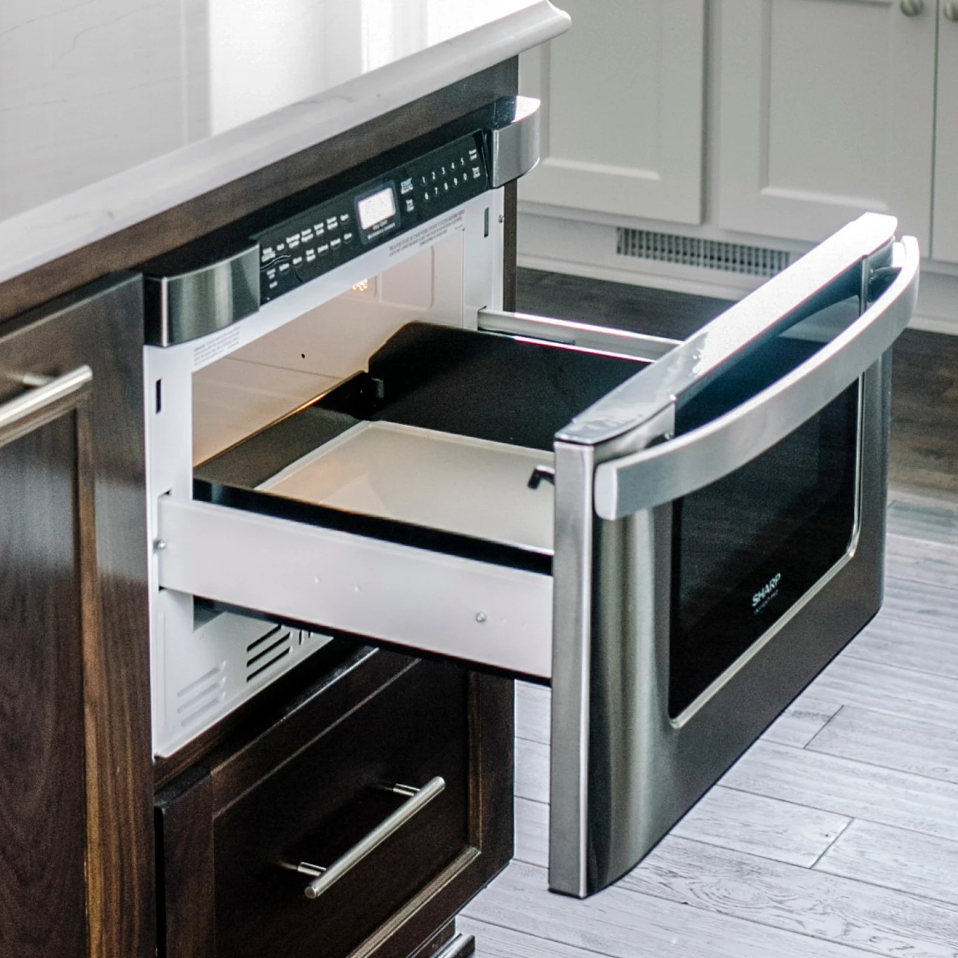 a Kitchen island with Ella quartz countertops and a microwave drawer
