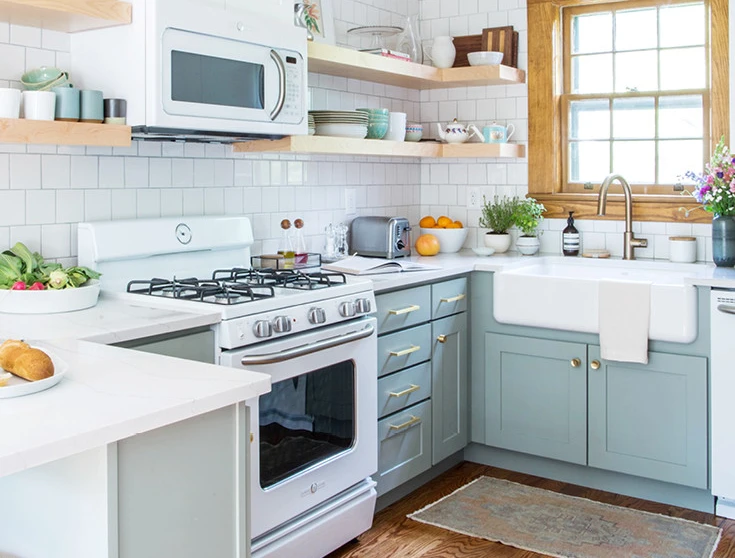 Kitchen with mint green cabinets, white quartz countertops and a farmhouse sink.