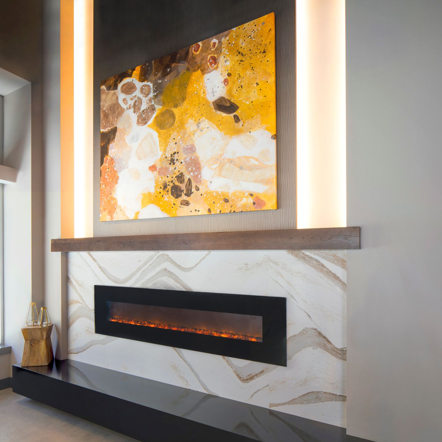  a Brittanicca Gold warm fireplace surround with a large colorful painting above it